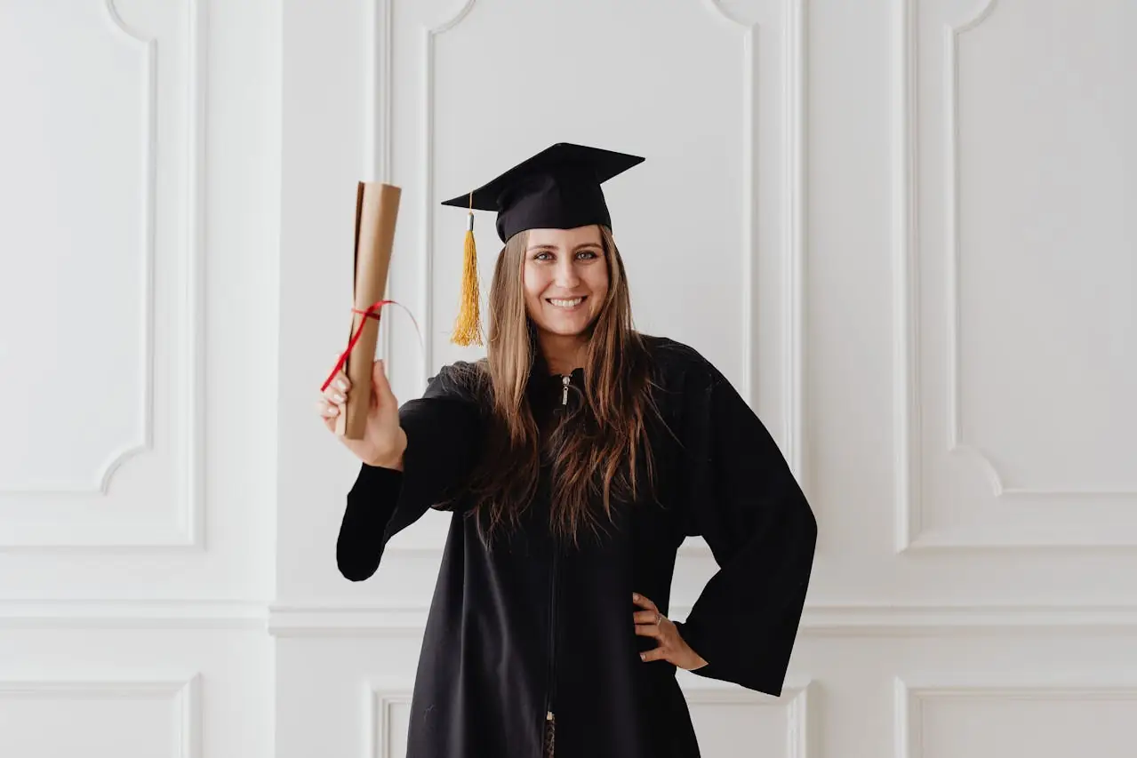 Djevojka u svečanoj haljini drži diplomu u ruci